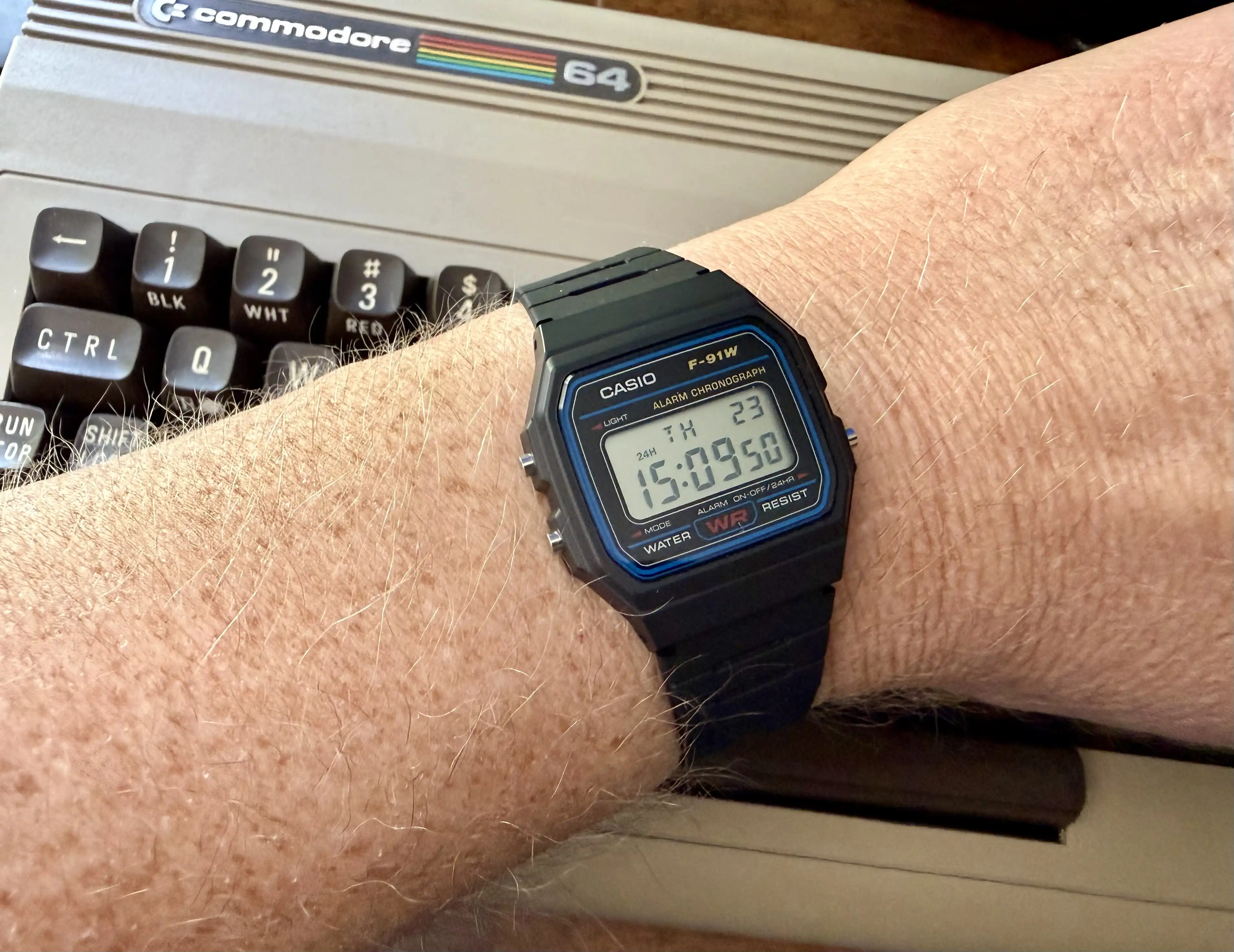 Casio F-91W on a stand next to a Commodore 64