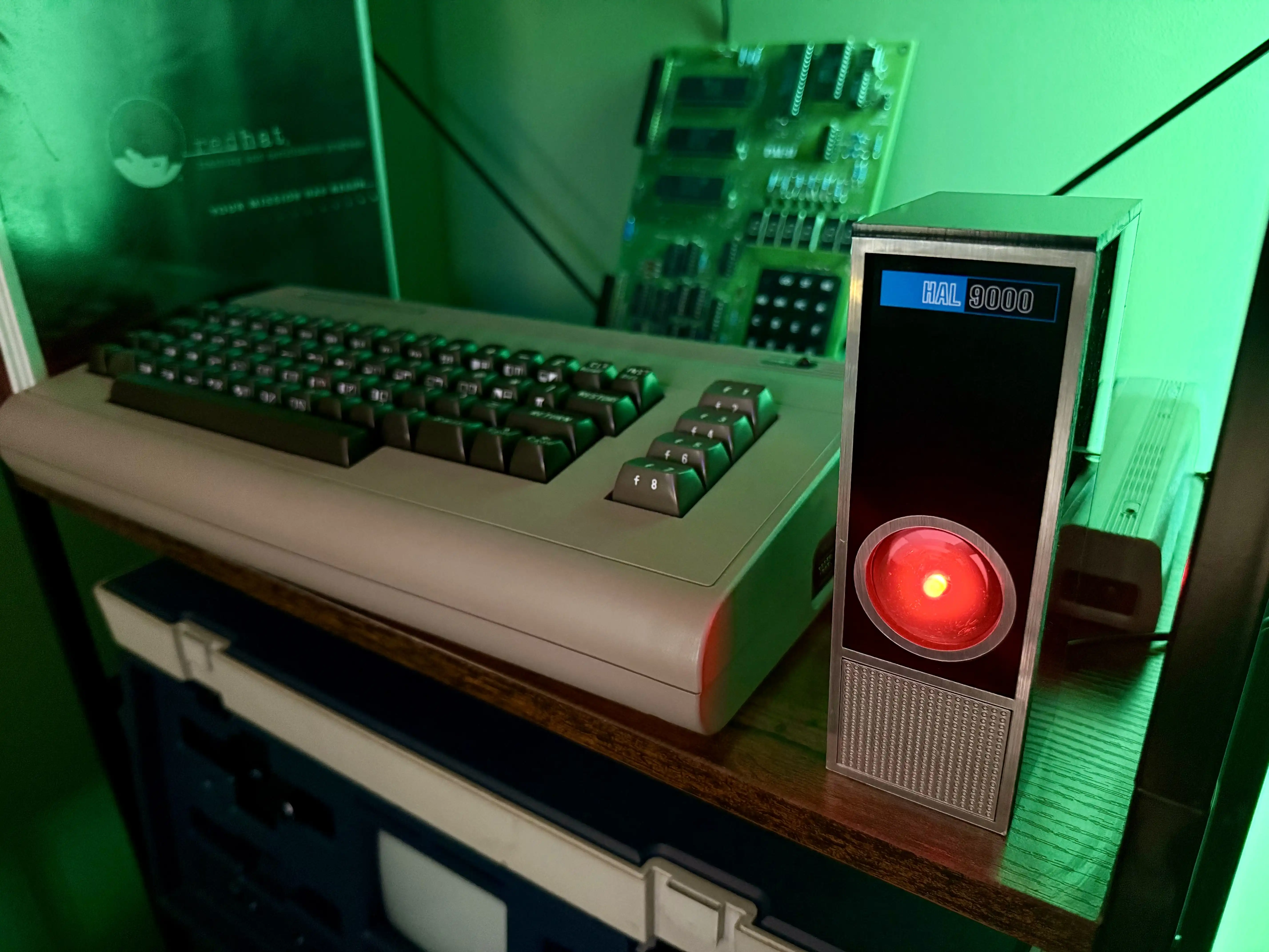 HAL 9000 replica next to a Commodore 64, lit by green light