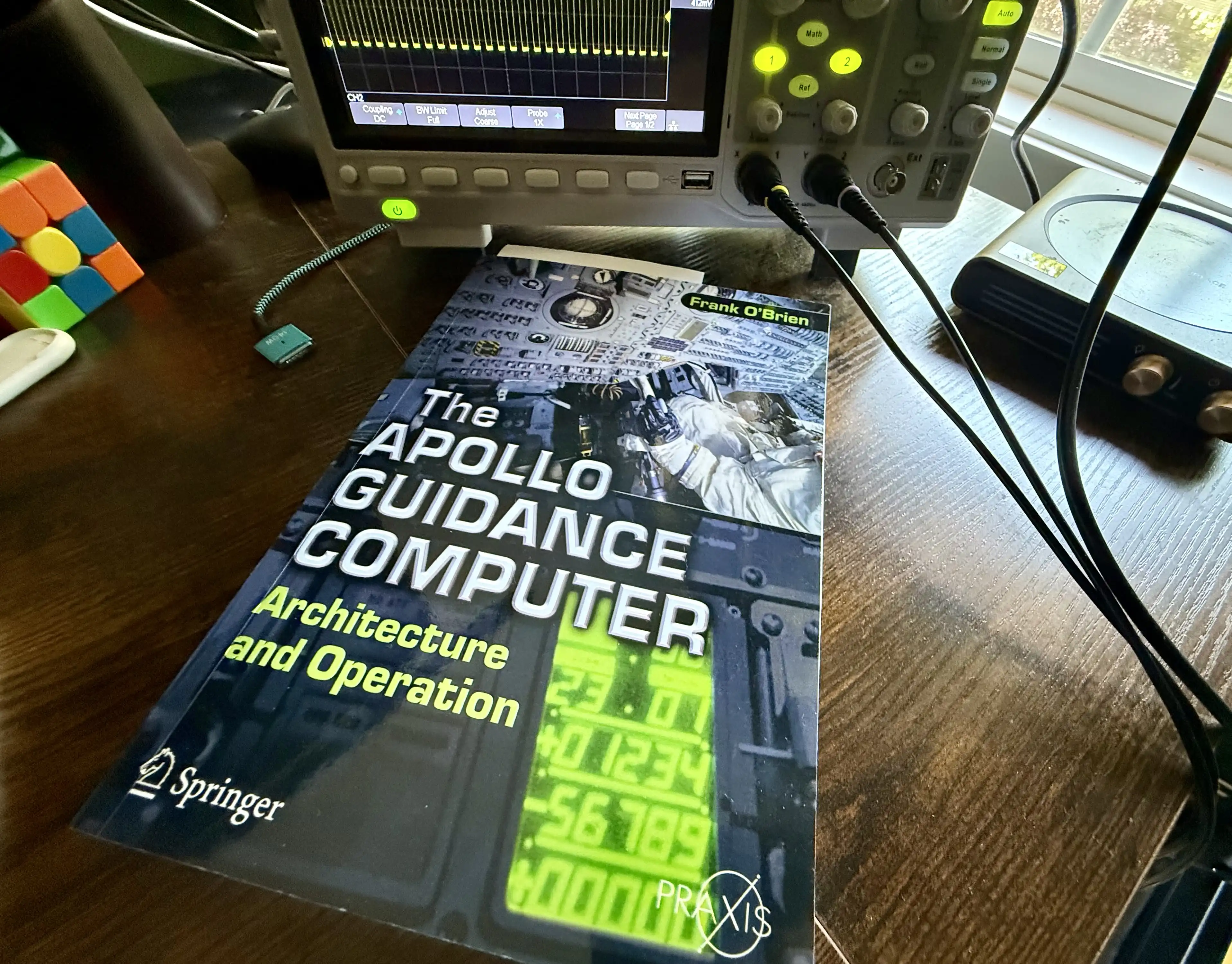 Frank O&rsquo;Brien&rsquo;s &ldquo;The Apollo Guidance Computer: Architecture and Operation&rdquo; on the workbench next to an oscilloscope